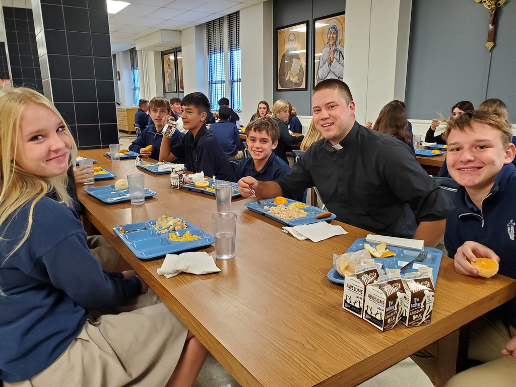 Fr. Andy sits with students during lunch at TMP-Marian.
