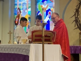 Jose Fernandez (8) and Carson Pinkney (8) served for Fr. Damian Richards during Mass.